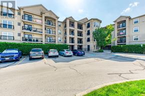 Burlington (Uptown) condo for rent - A parking lot in front of apartment buildings with cars parked.