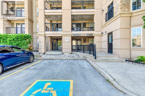 Burlington (Uptown) condo for rent - A blue car is parked in a handicapped parking spot in front of a building.