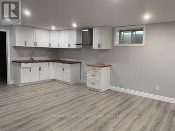 Burlington (Brant) apartment for rent - A kitchen with white cabinets and a wooden island.