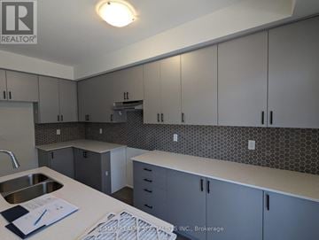 Oshawa (Donevan) townhouse for rent - A kitchen with grey cabinets and a white counter top.