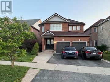 Mississauga (Meadowvale Village) apartment for rent - A house with a garage and two cars parked in front.