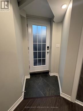 Mississauga (Meadowvale Village) apartment for rent - A white door with a glass window is in a hallway with a marble floor.