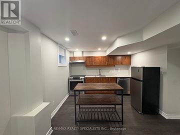 Mississauga (Meadowvale Village) apartment for rent - A kitchen with a wooden table and black appliances.