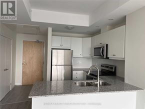 Kitchener condo for rent - A kitchen with a sink, refrigerator, and microwave.