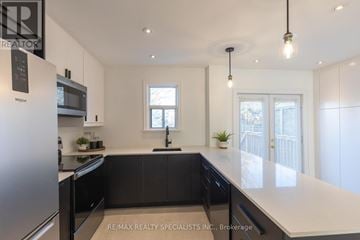Toronto (Stonegate-Queensway) apartment for rent - A modern kitchen with black cabinets and stainless steel appliances.
