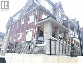Brampton (Northwest Brampton) townhouse for rent - A multi-story brick building with a black metal railing in front.