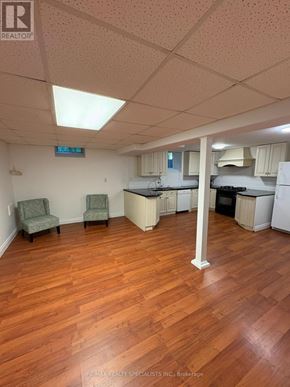 Hamilton (Meadowlands) apartment for rent - A room with wooden floors and a kitchenette in the background.