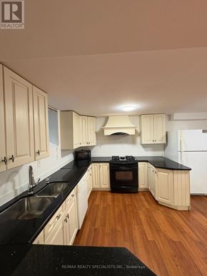 Hamilton (Meadowlands) apartment for rent - A kitchen with wooden cabinets and black countertops.
