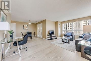 Mississauga (Hurontario) condo for rent - A spacious living room with a glass table and black chairs.