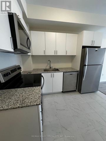 Toronto (Malvern) townhouse for rent - A kitchen with white cabinets and a granite counter top.