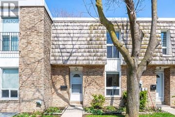 Toronto (Markland Wood) townhouse for rent - A brick building with a tree in front of it.