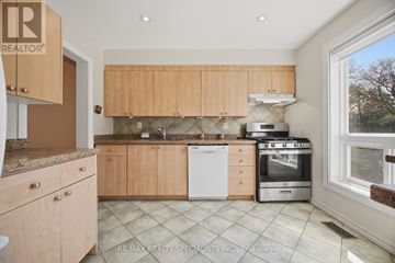Toronto (Markland Wood) townhouse for rent - A kitchen with wooden cabinets and a tile floor.