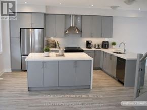 Mississauga (Lakeview) townhouse for rent - A modern kitchen with a refrigerator, sink, and cabinets.