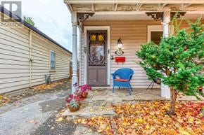 Burlington (Brant) apartment for rent - A house with a blue chair and a tree in front of it.