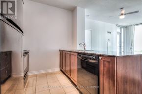 Mississauga (City Centre) condo for rent - A kitchen with wooden cabinets and a refrigerator.