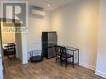 Toronto (Trinity-Bellwoods) apartment for rent - A living room with a glass table and chairs.