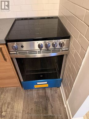 Toronto (Trinity-Bellwoods) apartment for rent - A stainless steel oven with a blue drawer in front of it.
