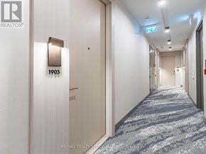 Toronto (Waterfront Communities) condo for rent - A hallway with a door numbered 1903 and a REALTOR® logo.