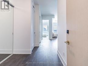 Toronto (Waterfront Communities) condo for rent - A hallway with a door on the left and a bathroom visible through the door.