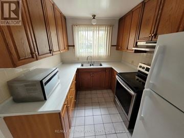 London East (East I) apartment for rent - A kitchen with wooden cabinets and white appliances.