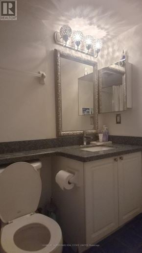 Toronto (Willowdale East) condo for rent - A bathroom with a toilet, sink and mirror.