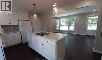 Windsor apartment for rent - A kitchen with white cabinets and a marble countertop.