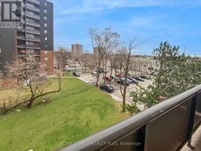 Mississauga (Applewood) condo for rent - A view from a balcony overlooking a parking lot and buildings.