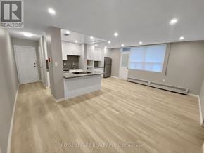 Mississauga (Applewood) condo for rent - A spacious, well-lit kitchen and living room with wooden flooring and white walls.