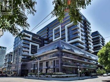 Toronto (Niagara) condo for rent - A modern multi-story building with a glass facade and balconies.