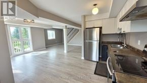Barrie (Georgian Drive) condo for rent - A kitchen with a stainless steel refrigerator and a sink.