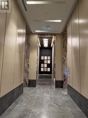 Toronto (Dovercourt-Wallace Emerson-Junction) condo for rent - A hallway with marble floors and beige walls leading to a black door.