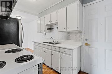 St. Catharines (Port Dalhousie) apartment for rent - A white kitchen with a stove and cabinets.