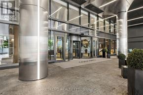 Toronto (Waterfront Communities) condo for rent - The lobby of a building with a large glass wall and a metal column.