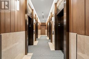 Toronto (Waterfront Communities) condo for rent - A hallway with wooden walls and elevators on either side.