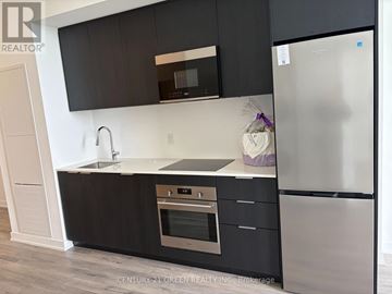 Brampton (Bram East) condo for rent - A kitchen with black cabinets and a stainless steel refrigerator.