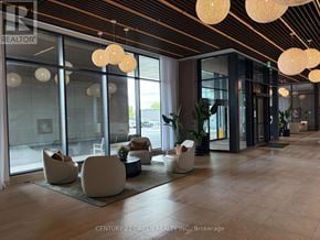 Brampton (Bram East) condo for rent - A modern waiting area with white chairs and hanging lights.