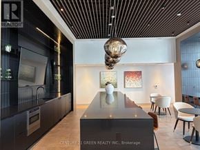 Brampton (Bram East) condo for rent - A modern kitchen with a long black island in the middle.