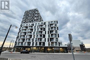 Oakville (Jm Joshua Meadows) condo for rent - A modern building with a glass facade is the focus of this image.