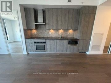 Toronto (Junction Area) condo for rent - A kitchen with wooden cabinets and a black countertop.