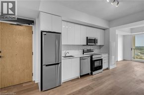 Brantford condo for rent - A modern kitchen with a refrigerator, microwave, and oven.