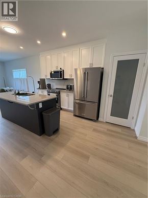 Simcoe townhouse for rent - A kitchen with a refrigerator, microwave, and oven.