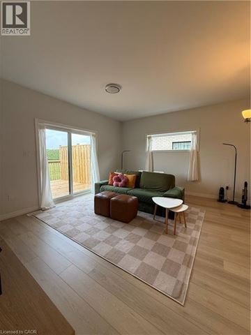 Simcoe townhouse for rent - A living room with a green couch and a brown ottoman.
