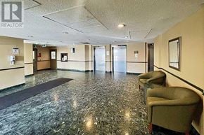 Mississauga (City Centre) condo for rent - A hallway with a marble floor and chairs on the side.