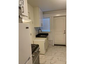 Vancouver apartment for rent - A kitchen with a stove top oven and a refrigerator.