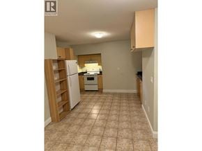 Coquitlam apartment for rent - A kitchen with a refrigerator, oven, and wooden cabinets.