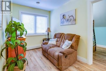 Fort Erie (Crystal Beach) duplex for rent - A living room with a brown couch and a painting of a bicycle on the wall.