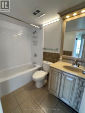 Toronto (Malvern) condo for rent - A white toilet sits in a bathroom next to a bathtub.