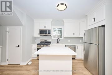 Fort Erie (Lakeshore) duplex for rent - A white kitchen with a refrigerator on the right.