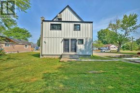 Fort Erie (Lakeshore) duplex for rent - A house with a grey exterior and a black roof is surrounded by a grassy lawn.