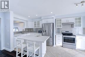 Burlington (Alton) townhouse for rent - A white kitchen with a large island and stainless steel appliances.